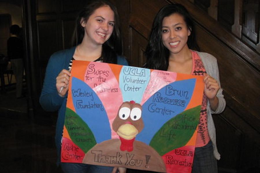 two students holding a paper turkey